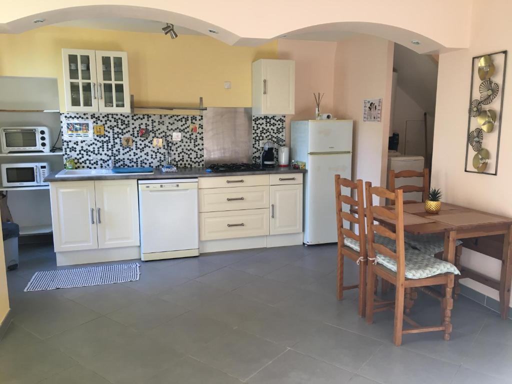 a kitchen with white appliances and a table and chairs at Appartement climatisé 1 à 4 personnes avec belle terrasse in Vidauban