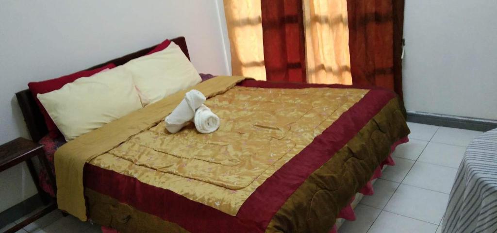 uma cama com um bicho de peluche sentado em cima dela em Melrose homestay and transport em Bandar Seri Begawan