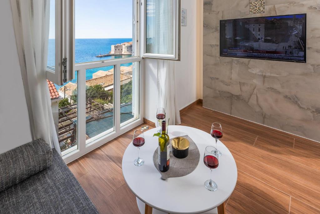 una sala de estar con una mesa con copas de vino en Apartment Flora, en Dubrovnik
