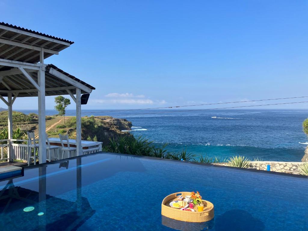 a swimming pool with a view of the ocean at Kov Ceningan in Nusa Lembongan