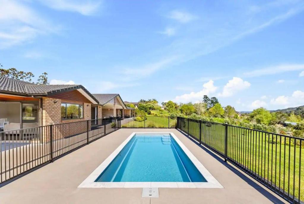 a swimming pool on the balcony of a house at Luxury Modern 3-BDR Oasis in Kumeu