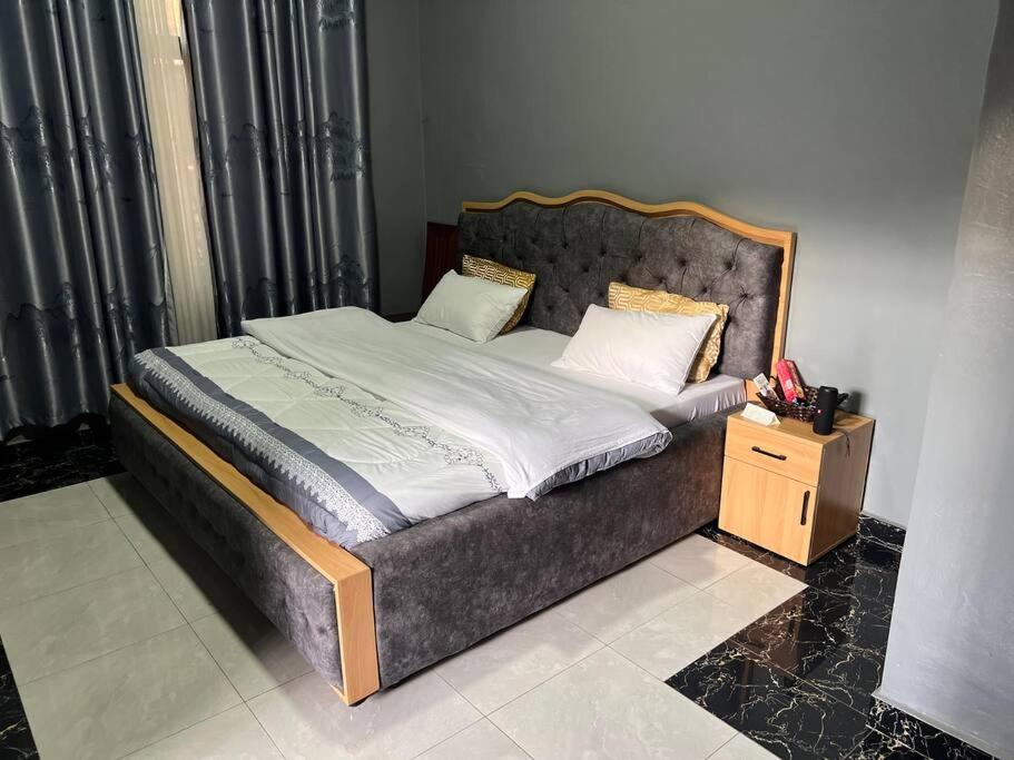 a bedroom with a large bed with a wooden frame at 2 bedroom apartment in Musanze( Benji) in Ruhengeri