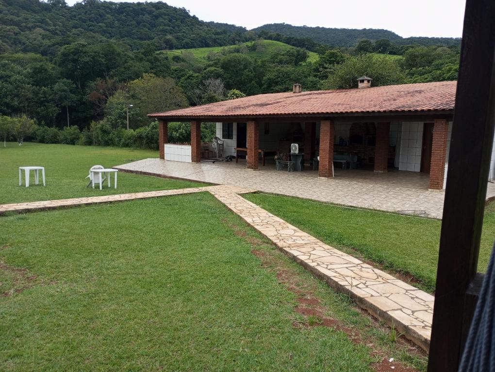 um edifício com uma mesa e cadeiras num quintal em Chácara linda em Extrema em Extrema