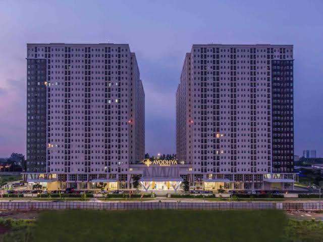 two tall buildings in a city at night at Apartement Ayodhya by Alam Sutera in Tjikokol