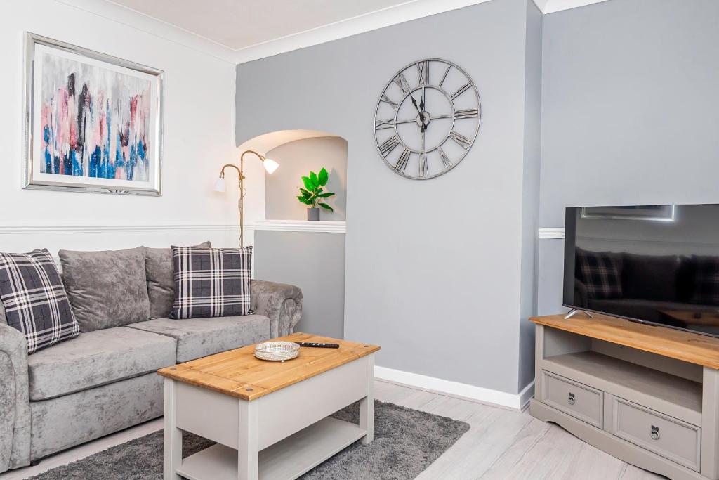 a living room with a couch and a tv at Private immaculate contractor and leisure stay with large driveway in Birmingham