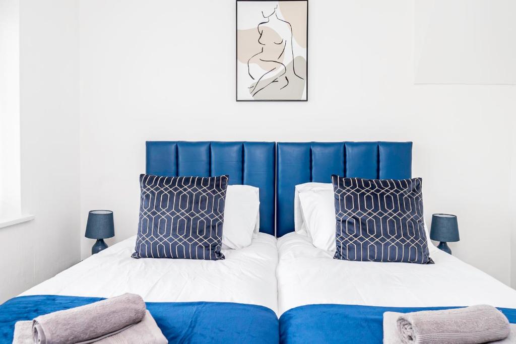 1 dormitorio con 1 cama azul y blanca y 2 almohadas en Private immaculate contractor and leisure stay with large driveway en Birmingham