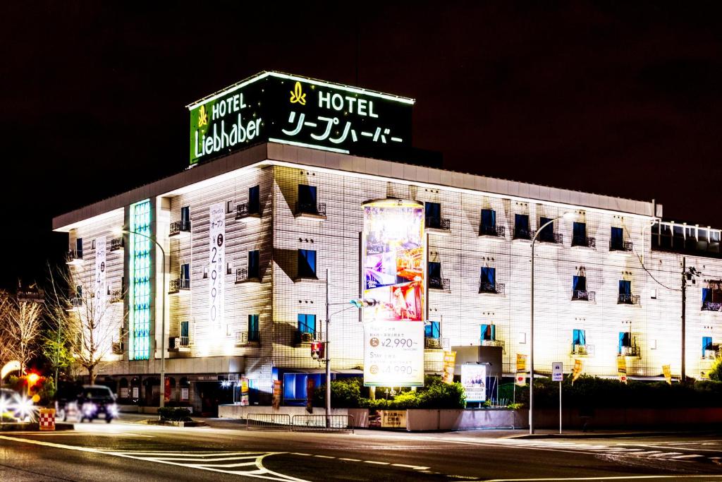a hotel with a sign on top of it at night at Hotel Liebhaber -Adult Only in Hirakata