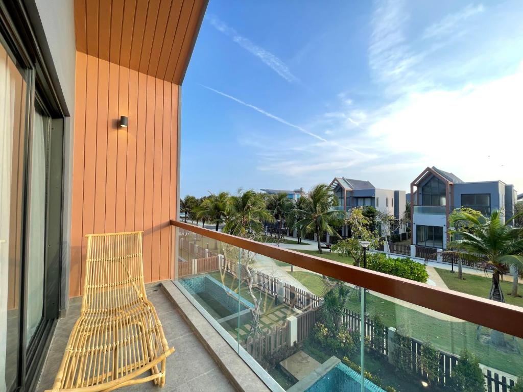 a balcony with a bench and a swimming pool at Tropicana Hồ Tràm - Seashell Villa in Ho Tram