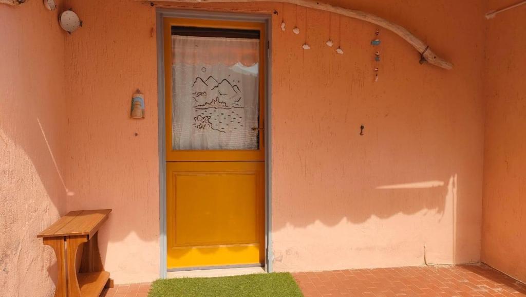 a yellow door in the corner of a building at Isola del Giglio Casa Cecilia GIGLIO Porto loc Monticello in Isola del Giglio