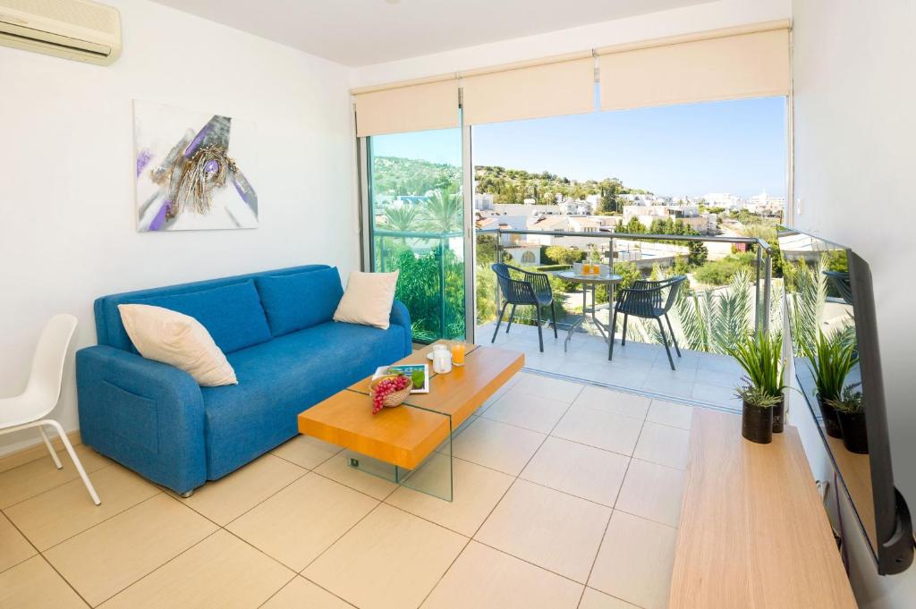 een woonkamer met een blauwe bank en een tafel bij LULA - Beachfront Apartment in Paralimni