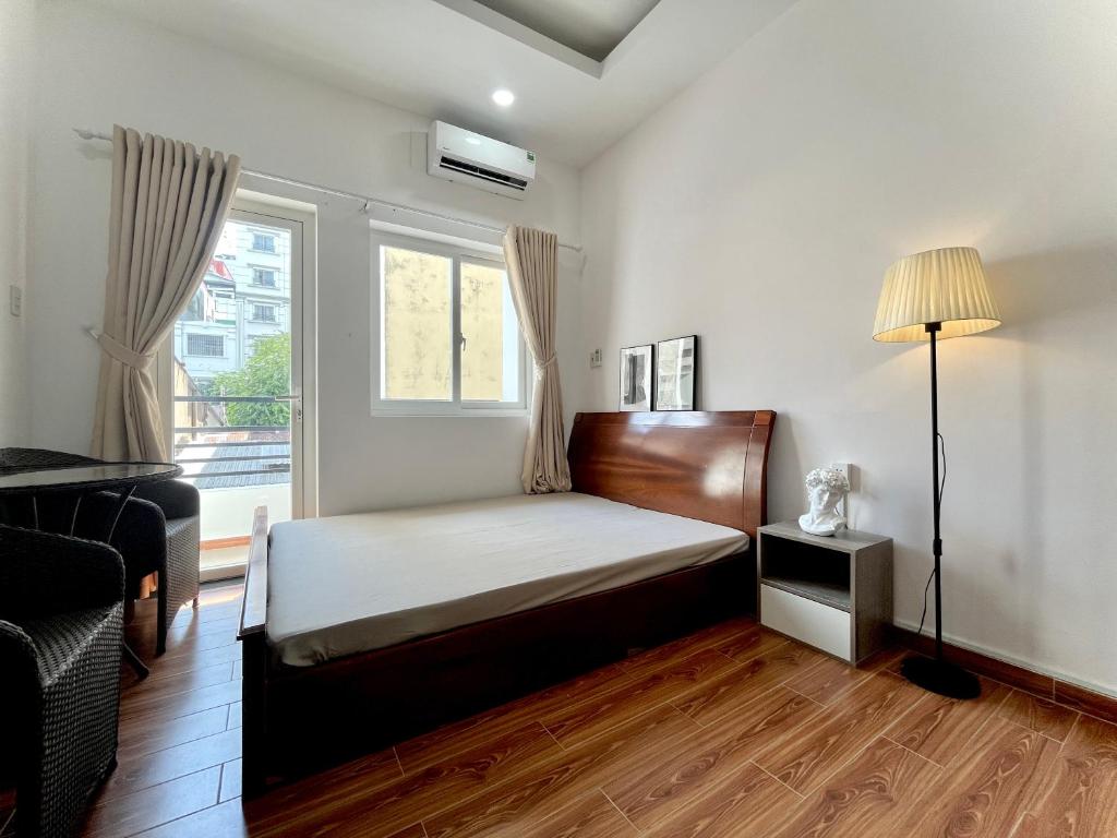 een slaapkamer met een bed en een raam bij Taibo house 2 in Ho Chi Minh-stad