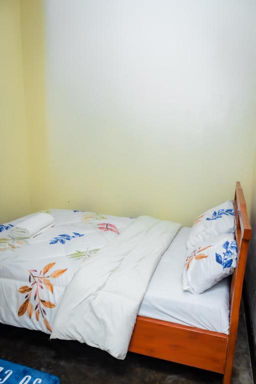 ein Bett mit weißer Bettwäsche und Kissen darauf in der Unterkunft Rhoja homes in Ruhengeri