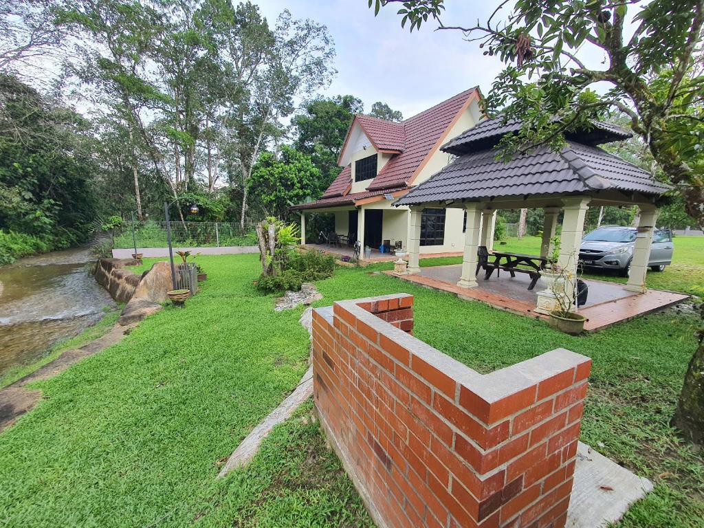 a house with a brick wall in the yard at Teratak D Tuntung in Kampong Mesjid