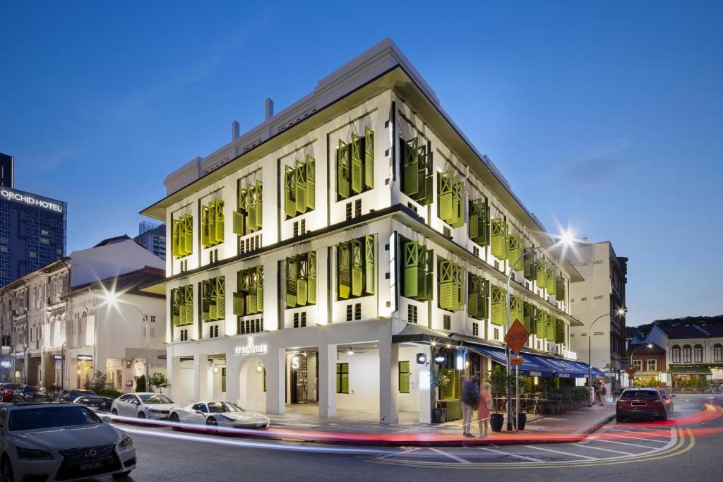 a white building with green windows on a city street at ST Signature Tanjong Pagar in Singapore