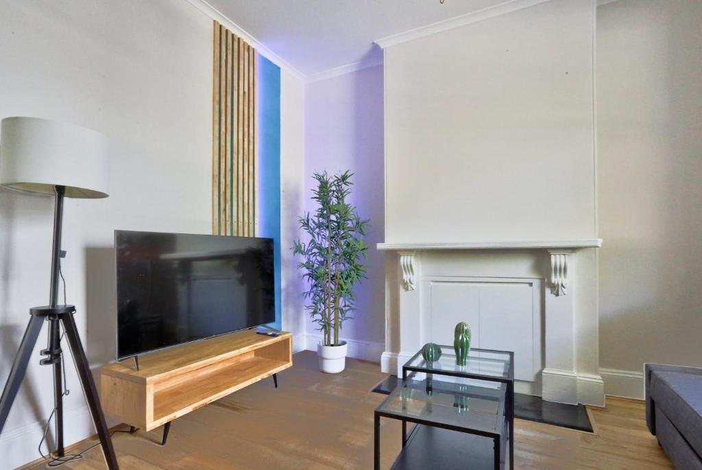 sala de estar con TV de pantalla plana grande en 2 Bedroom House with 2 E-Bikes Included at Centre of Chippendale, en Sídney
