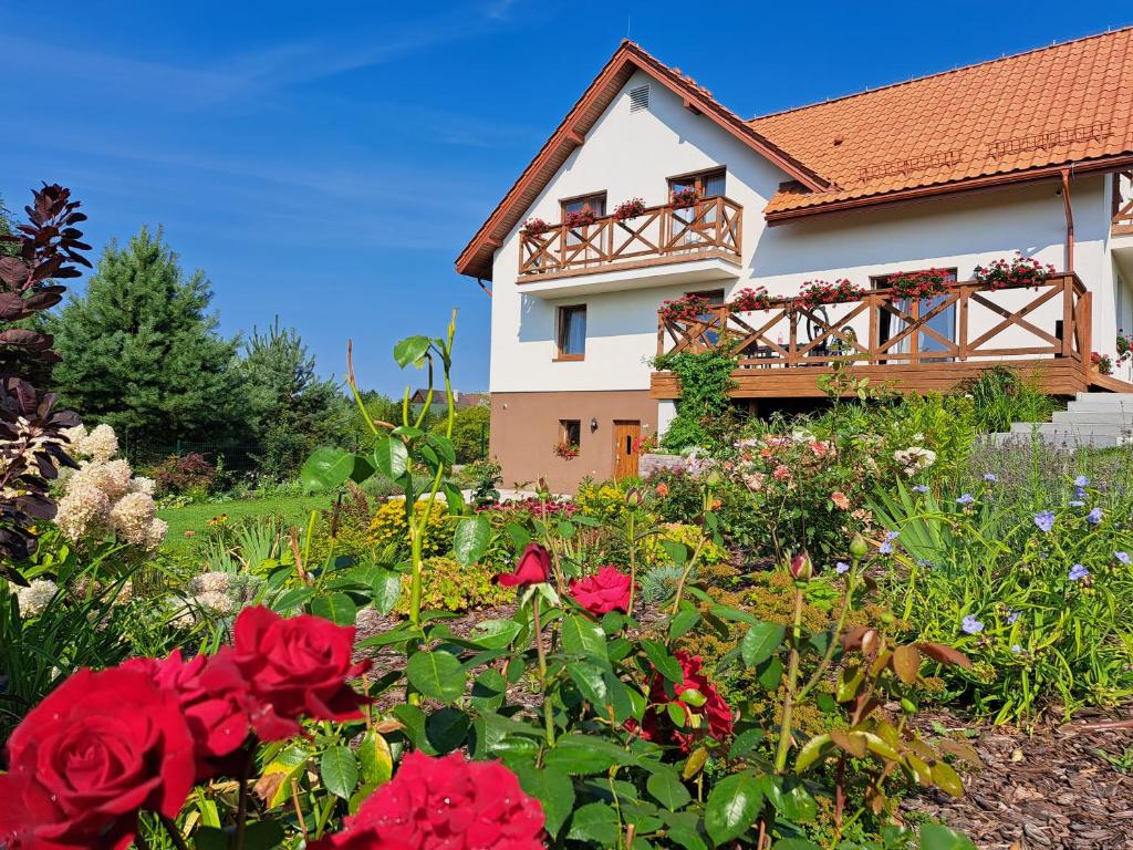 dom z ogrodem kwiatów przed nim w obiekcie Pensjonat Willa Polesie w Supraślu