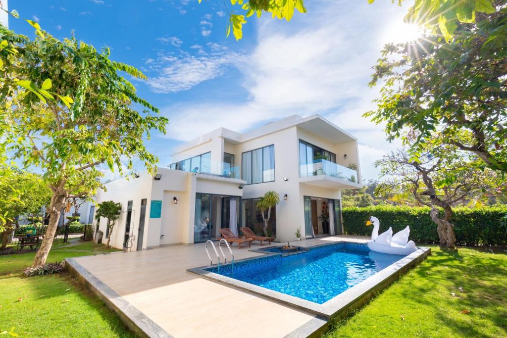 uma villa com piscina em frente a uma casa em Palm Villa 36 (Luxury Villa inside Resort near The Sea) em Vung Tau