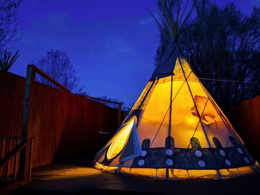 a lit up tent sitting on a patio at night at Moab RV Resort Glamping Tipi OK56 in Moab