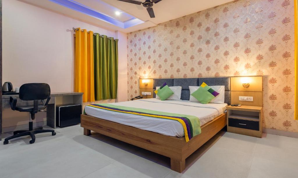 a bedroom with a bed and a desk and a chair at Treebo Trend Shakuntalam in Lucknow