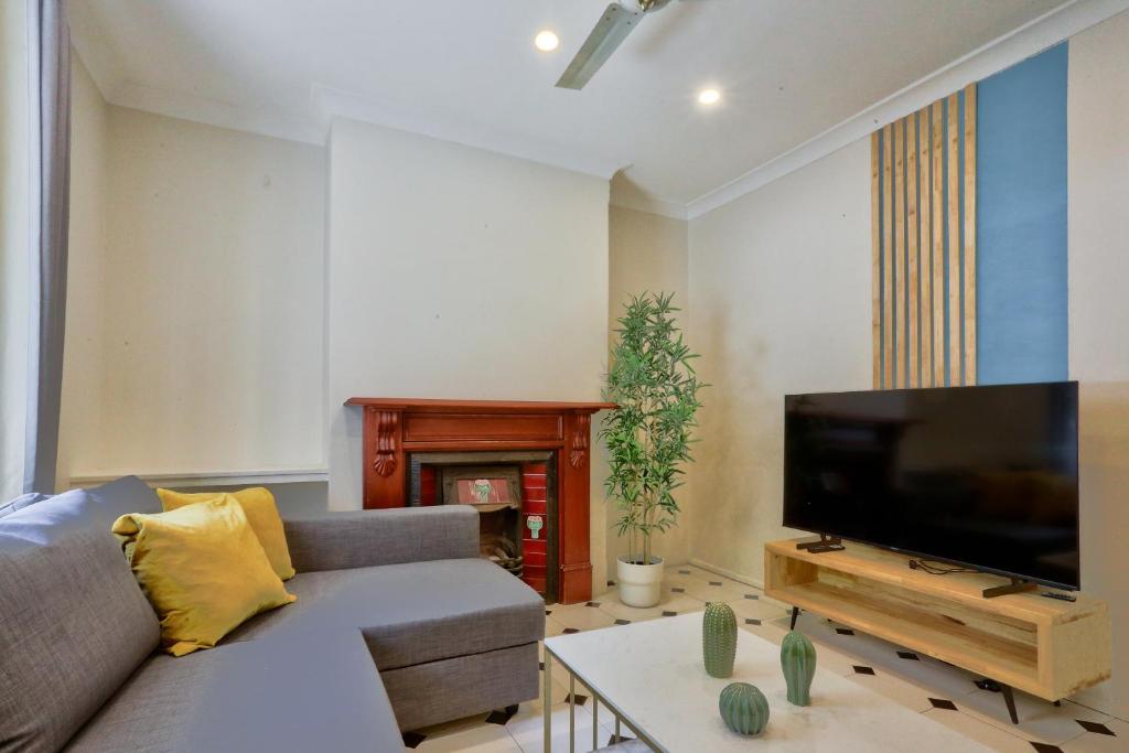 a living room with a couch and a flat screen tv at Affordable 3 Bedroom House Darlinghurst with 2 E-Bikes Included in Sydney