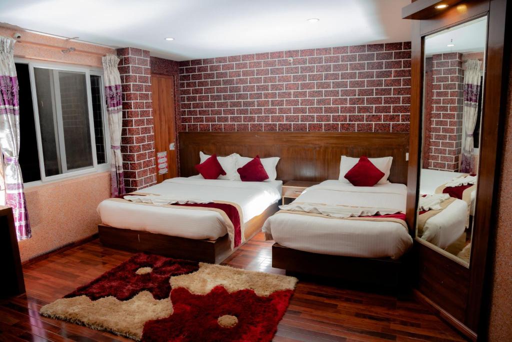 1 dormitorio con 2 camas y pared de ladrillo en Rosemary Homes Pokhara, en Pokhara