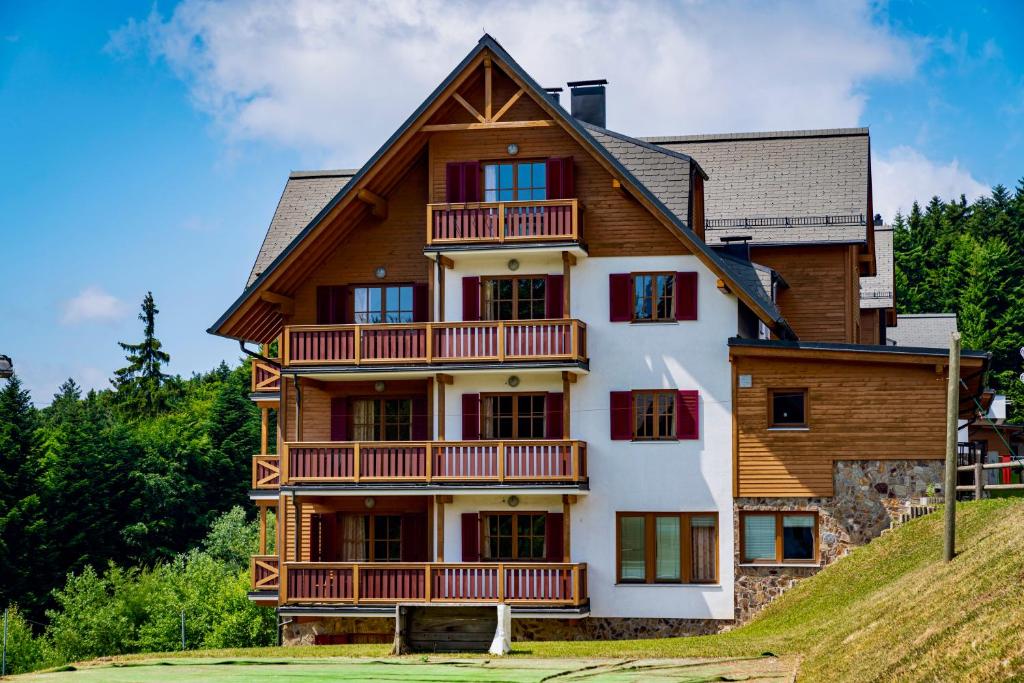 ein Haus auf einem Hügel in der Unterkunft Pohorje Village Wellbeing Resort - Forest Apartments Videc in Hočko Pohorje