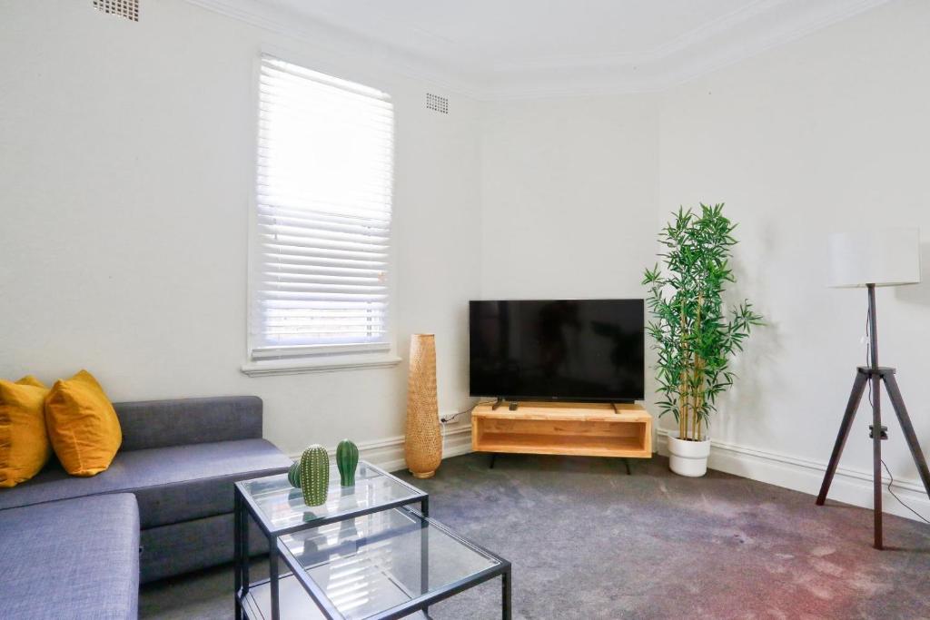 a living room with a couch and a flat screen tv at Unique 2 Bedroom Darling Harbour Glebe 2 E-Bikes Included in Sydney