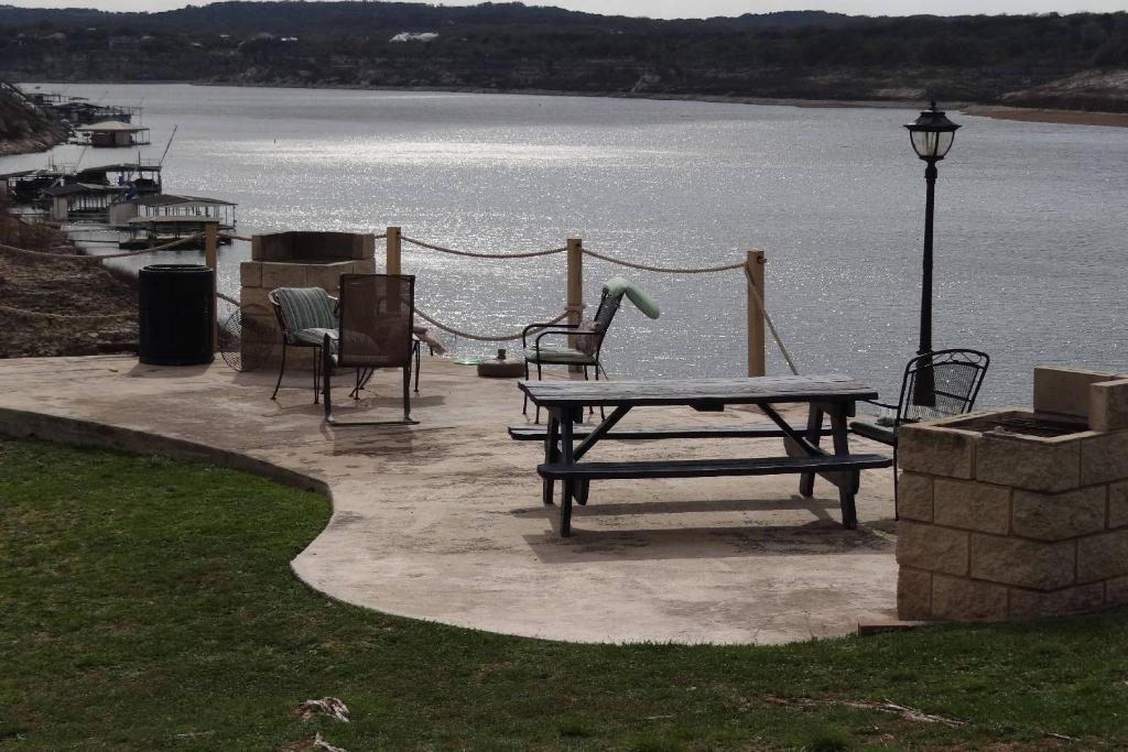 una mesa de picnic y sillas junto a un cuerpo de agua en 3107 The Island, en Lago Vista