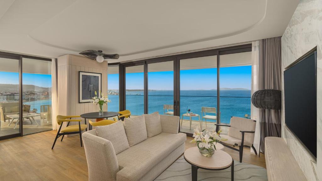 a living room with a couch and views of the ocean at Swissotel Resort And Spa Cesme in Çeşme