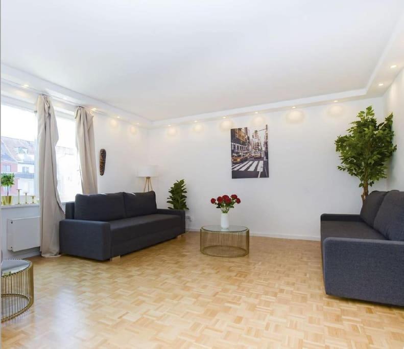 a living room with two blue couches and a table at 2: Schöne Schwabing 70m² sannierte City Wohnung in Munich