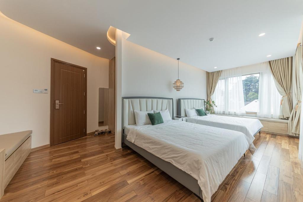 Postel nebo postele na pokoji v ubytování Jodi Dalat Hotel