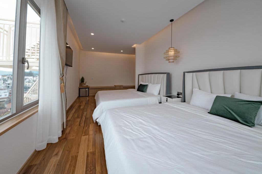 Postel nebo postele na pokoji v ubytování Jodi Dalat Hotel