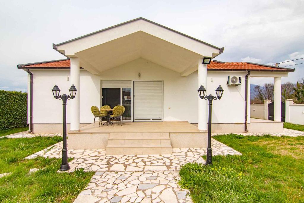 Uma casa branca com duas luzes à frente. em Deluxe Holiday Home-Podgorica em Podgorica