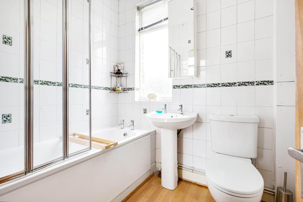 a bathroom with a toilet and a sink and a tub at Room with a view Catford, homestay in Hither Green
