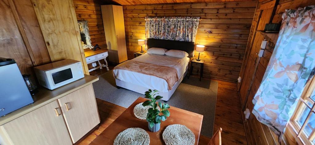 Tegwaan's Nest B&B في مويريفير: غرفة نوم صغيرة بها سرير وتلفزيون