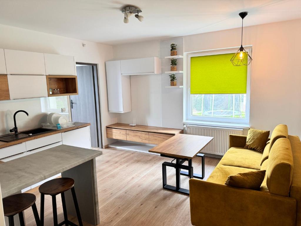 Il dispose d'une cuisine et d'un salon avec un canapé et une table. dans l'établissement Apartament Juhas, à Limanowa