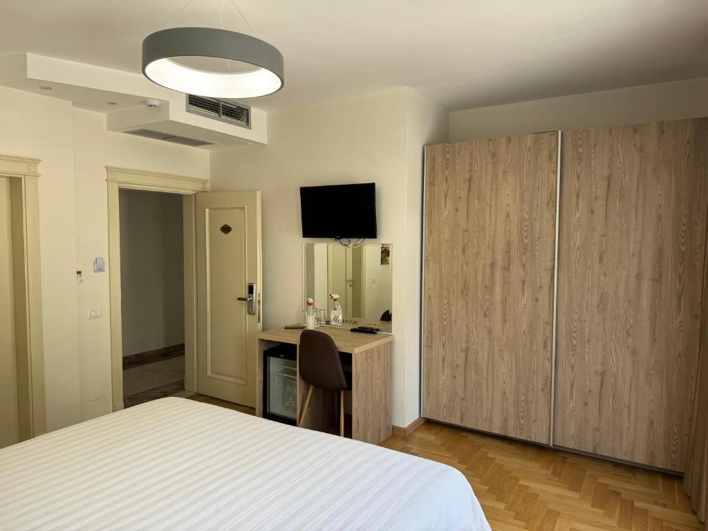 una camera con letto, scrivania e TV di Mervin Hotel a Krujë (Kruja)