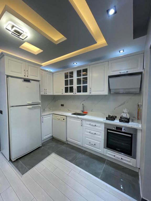 uma cozinha com armários brancos e um frigorífico branco em Sabiha Gökçen Airport & Metro em Istambul