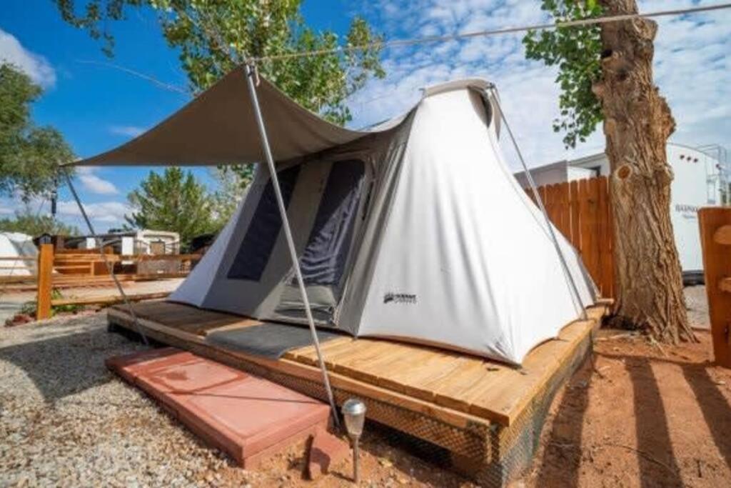 uma tenda sentada numa plataforma de madeira sob uma árvore em Moab RV Resort Glamping Setup Tent in RV Park #2 OK-T2 em Moab