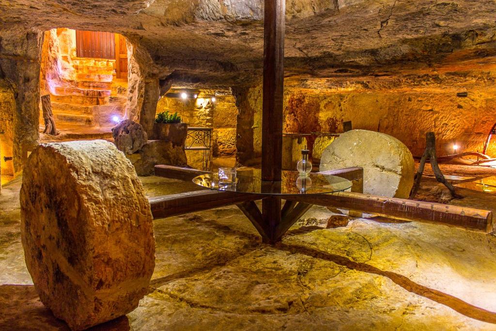a stone room with a table in a cave at Masseria Valente in Ostuni
