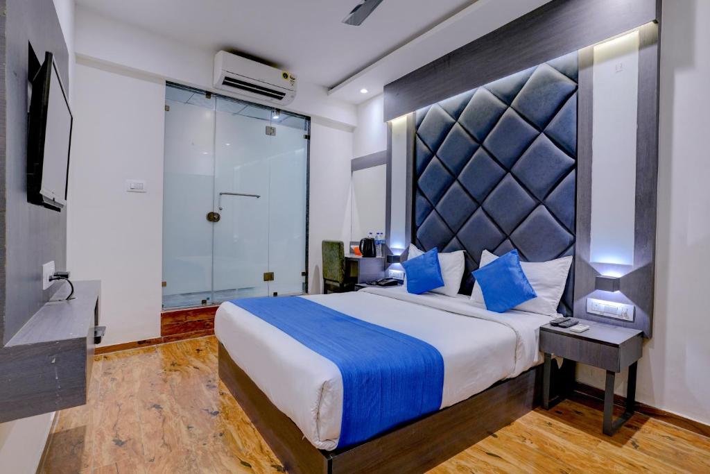 a bedroom with a large bed with blue pillows at Hotel Gorrion in Mumbai