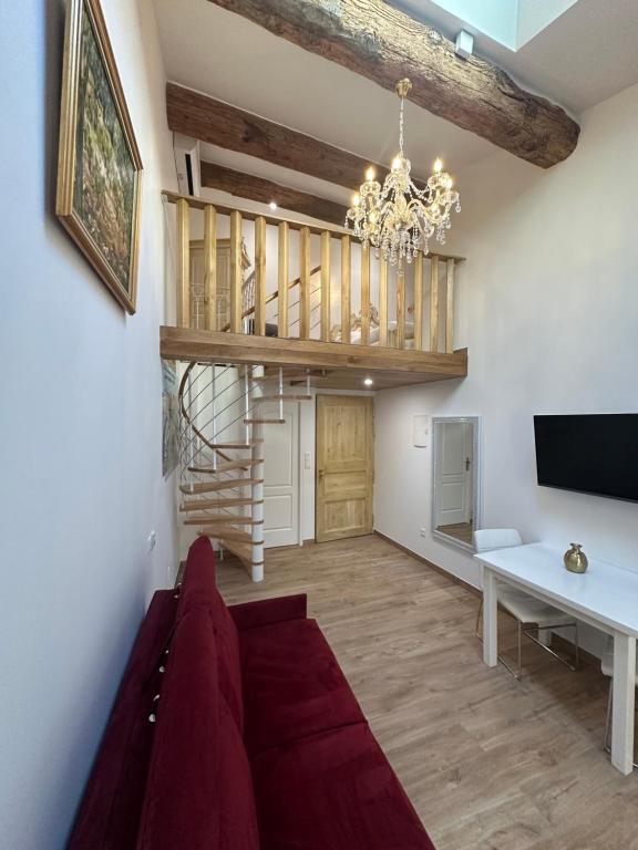 sala de estar con escalera y lámpara de araña en Studio familial a Mezzanine presbytère dans l'Église, en Narbona