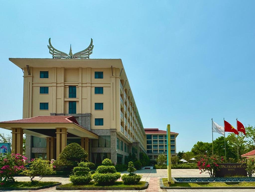 Muong Thanh Holiday Hoi An Hotel في هوي ان: مبنى الفندق عليه تمثال