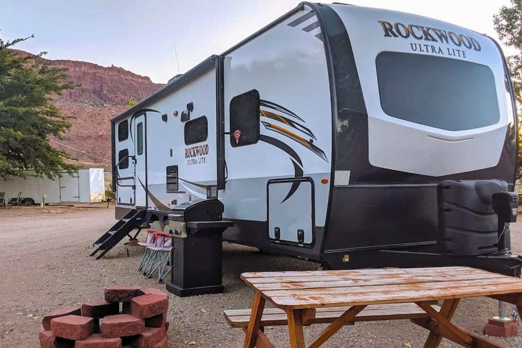 een witte camper geparkeerd naast een picknicktafel bij Moab RV Resort Glamping RV Setup OK33 in Moab