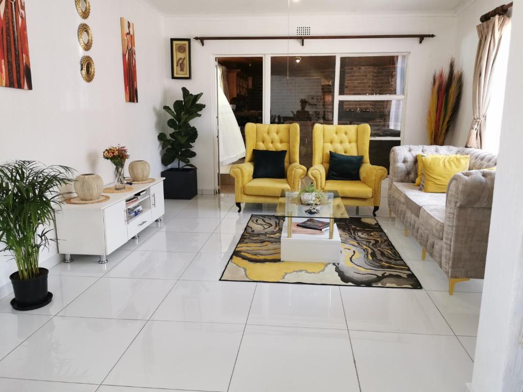 a living room with yellow chairs and a table at Stunning 2 Bedrooms and 2 Bathroom No loadshedding in Johannesburg