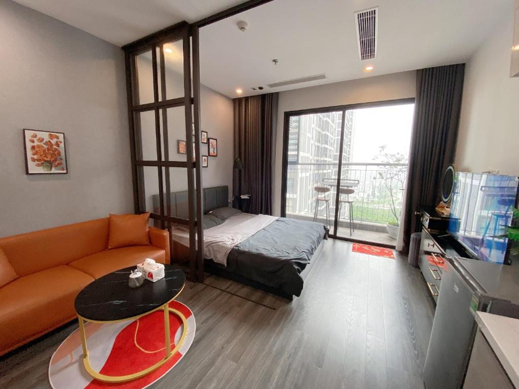 um quarto com uma cama, um sofá e uma mesa em Homestay Vinhome Ocean Park R103 em Gia Lâm Pho