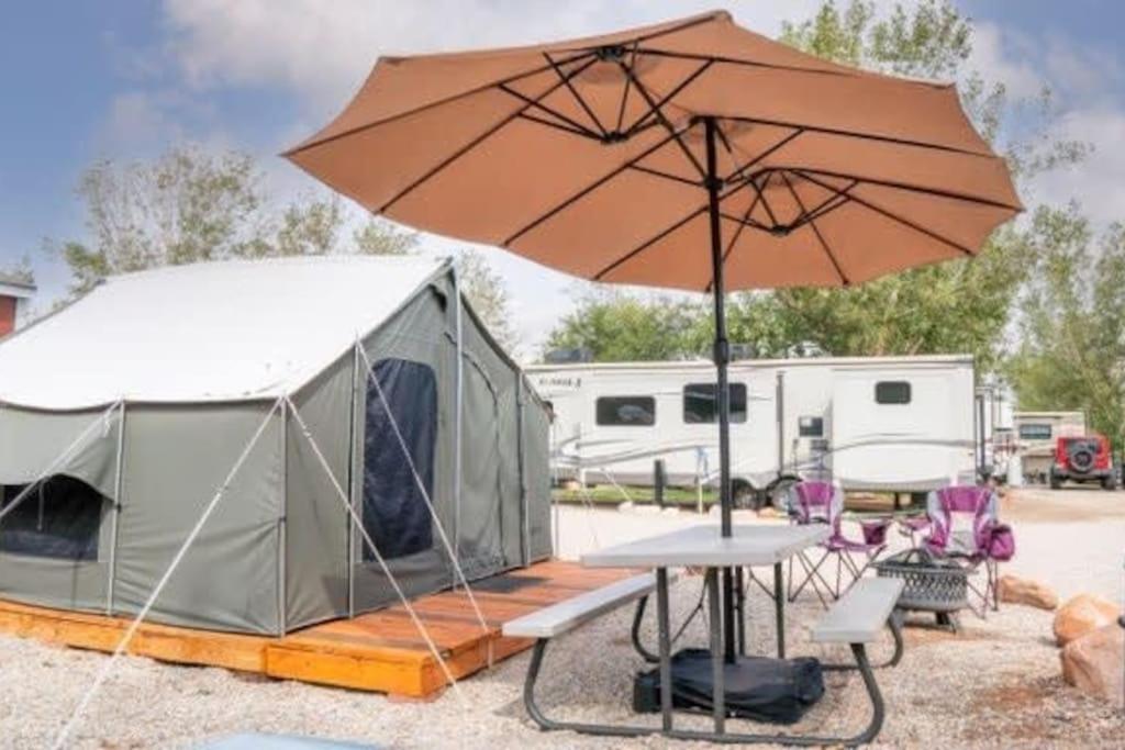 a tent and a table with an umbrella at Moab RV Resort Glamping Setup Tent in RV Park #4 OK-T4 in Moab