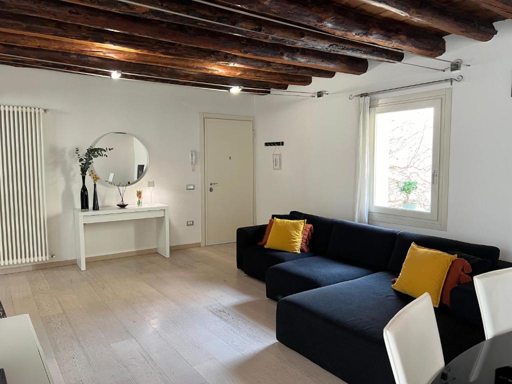 - un salon avec un canapé bleu et un miroir dans l'établissement Ca' Del Vecio, in centro storico, Piazza Garibaldi, à Bassano del Grappa