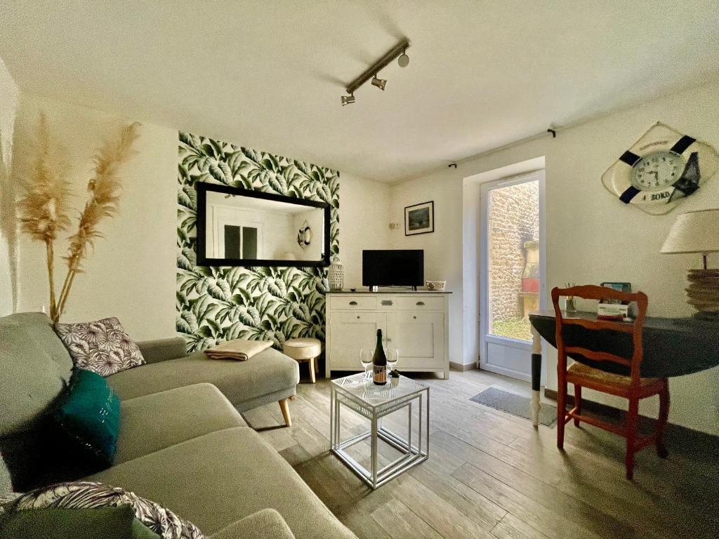a living room with a couch and a table at Beach House & Patio by Melrose in Arromanches-les-Bains