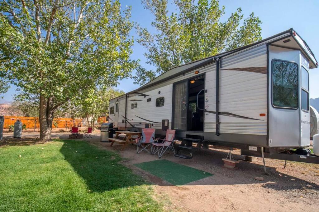einen Wohnwagen, der in einem Garten mit einem Tisch und Stühlen geparkt ist in der Unterkunft Moab RV Resort Glamping Large RV Setup OK63 in Moab